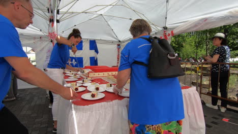 Public-banquet,-canada-day,-hostess-serving-cake-to-people,-happy-birthday-party,-gourmet-event,-festival,-national-canada-day-ceremony
