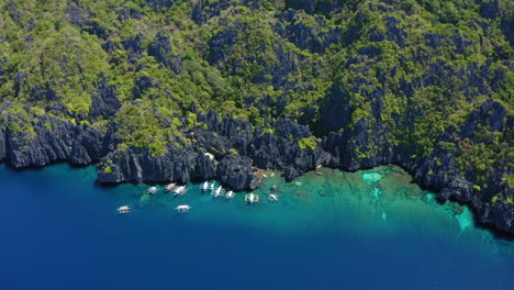 Aerial-view-of-Hidden-lagoon,-with-many-spider-boats-parked,-Coron,-Palawan,-Philippines
