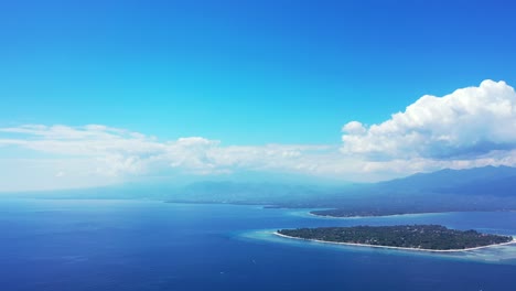 Wunderschöne-Landschaft-In-Indonesien-Mit-Blauem,-Ruhigem-Meer-Und-Wolkenverhangenem-Blauen-Himmel-Darüber---Luftaufnahme