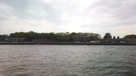 Governors-Island-entrance-and-waterfront-from-boat,-sailing-in-Upper-Bay-of-New-York-City
