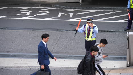 Zeitlupe-Eines-Japanischen-Verkehrsbeamten,-Der-Freundlicherweise-Den-Verkehr-Auf-Einer-Straße-Regelt