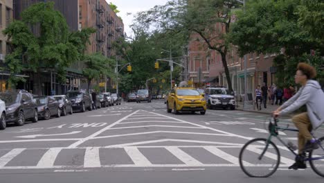 Traffic-at-the-intersection-of-Bleecker-Street-and-Christopher-Street-on-a-summer-day-in-Greenwich-Village,-Manhattan,-New-York-City