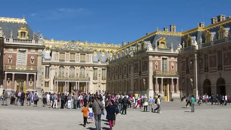 Pan-view-of-people-walking-outside-of-the-Versailles-Palace,-Paris,-France