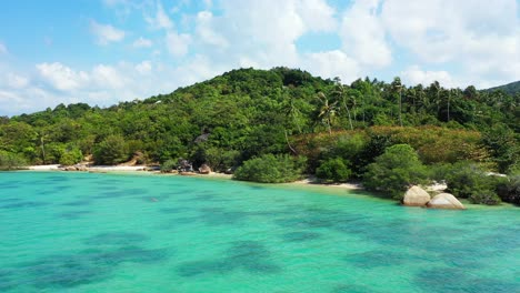 Blaue-Türkisfarbene-Lagune,-Die-Einen-Privaten-Exotischen-Strand-Umspült,-Der-Von-üppiger-Vegetation-Und-Großen-Kalksteinklippen-An-Der-Küste-Einer-Tropischen-Insel-In-Thailand-Versteckt-Wird