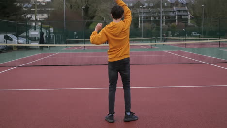 A-mother-and-son-practicing-tennis-in-an-outdoor-court,-family-time---slowmo