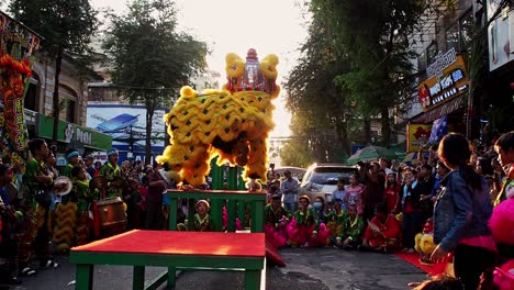 Menschen-Beobachten-Den-Gelben-Drachen-Beim-Tanzen-Mitten-Auf-Der-Straße-In-Phnom-Penh,-Kambodscha,-Während-Sie-Das-Chinesische-Neujahr-Feiern-–-Totale