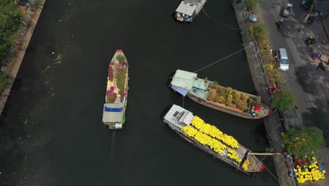 Aerial-view-following-a-boat-down-the-canal-of-floating-flower-market-in-Saigon-or-Ho-Chi-Minh-City-in-Vietnam