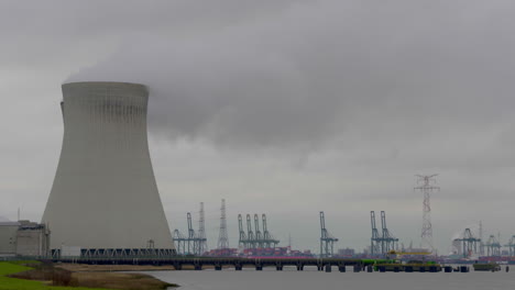 Una-Planta-De-Energía-Nuclear-Junto-Al-Puerto-De-Antwerp-En-Bélgica-Con-Vapor-Que-Sube-Al-Aire-Desde-La-Torre-De-Enfriamiento---Plano-General