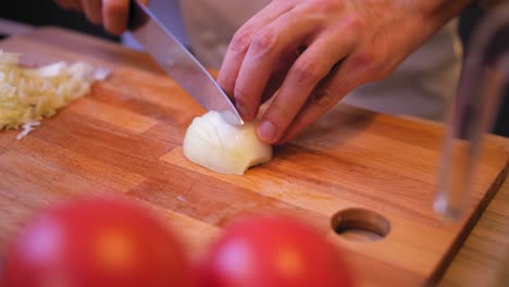 cook-cuts-the-onion-on-a-wooden-board