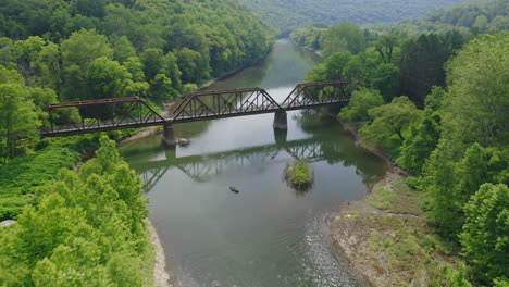 Luftdrohnen-Fliegen-über-Dem-Blue-River-Und-Abenteuerlustige-Menschen-In-Kajaks-Entlang-Eines-Leuchtend-Grünen-Waldes-In-Zentral-Pennsylvania-Im-Sommer