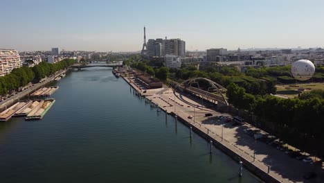 Train-runs-along-bank-of-Seine-with-Eiffel-Tower-in-background