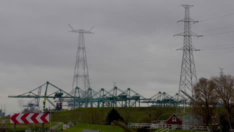 Líneas-Eléctricas-Que-Se-Elevan-Sobre-El-Sitio-Industrial-Del-Puerto-De-Antwerp,-Bélgica-En-Un-Día-Nublado---Toma-Amplia