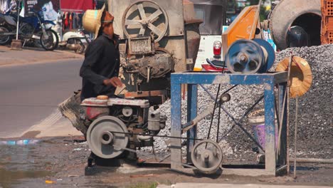 Medium-Shot-of-a-Worker-Supervising-a-Gasoline-Powered-Pulley-Machine-at-the-Construction-Site