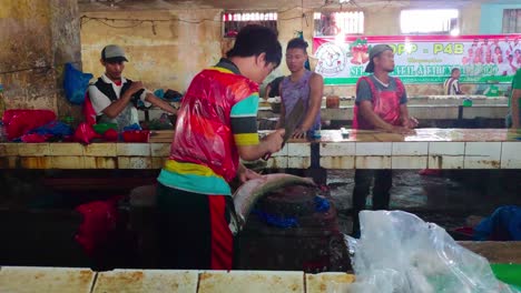 Fishmonger-cuts-open-a-fish-in-an-unsanitary-fish-traditional-market