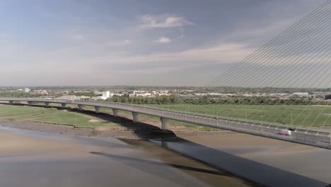 Modern-landmark-Mersey-Gateway-transport-bridge-drone-aerial-view-pan-right-across-skyline