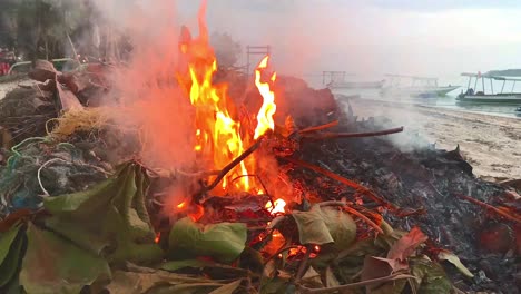 Burning-trash-and-waste-on-tropical-beach-during-dusk-in-evening