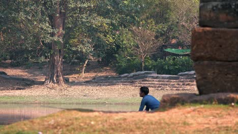 Asian-Fisherman-Casting-His-Rod-Into-the-Moat-at-Angkor-Wat-in-Cambodia