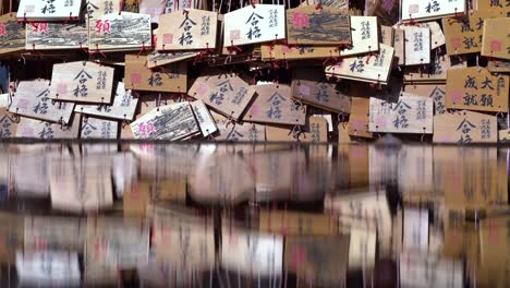 Tarjetas-De-Deseos-Japonesas-Reflexionando-Sobre-El-Agua-En-El-Santuario-En-Japón---Toma-De-Primer-Plano