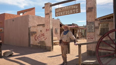 Ein-Cowboy-Schauspieler-Posiert-Bei-Schönem-Wetter-Am-Eingang-Alter-Tombstone-Schießereien-In-Tombstone,-Arizona-–-Zeitlupe
