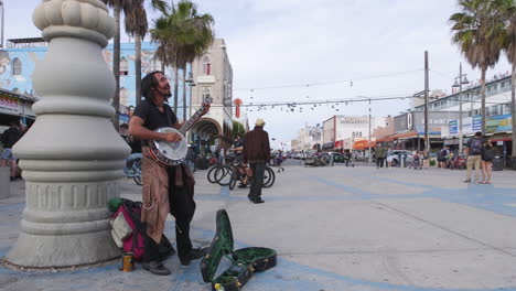 Un-Músico-Callejero-Actuando-Con-Un-Banjo-En-El-Paseo-Marítimo-De-Venice-Beach-En-Los-Angeles