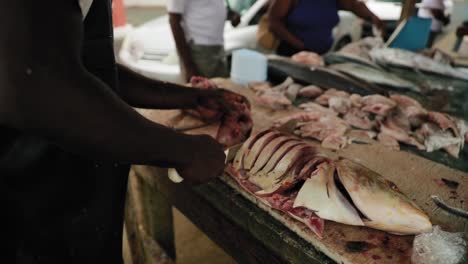 Local-butchering-a-fish-on-the-beach-in-Tobago,-West-indies