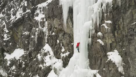 Luftaufnahme-Eines-Einsamen-Bergsteigers,-Der-Den-Gefrorenen-Wasserfall-Maineline-Erklimmt,-Mount-Kineo-4k