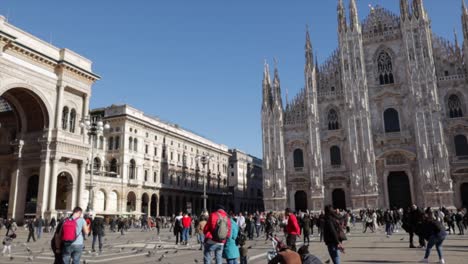 Duomo-di-Milano-square-witht-both-the-cathedral-and-the-galleria-vittorio-emanuele-II-in-a-wide-shot-pan-during-bright-sunny-day-in-Milan-Italy
