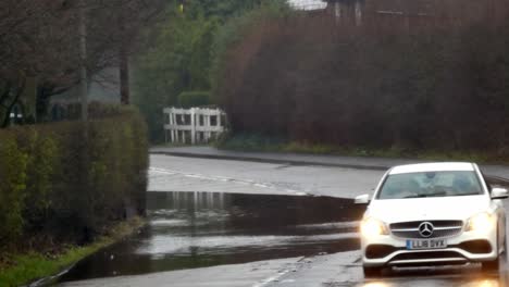 Vehículos-Maniobrando-Alrededor-De-Stormy-Flash-Inundado-Road-Corner-Bend-Uk