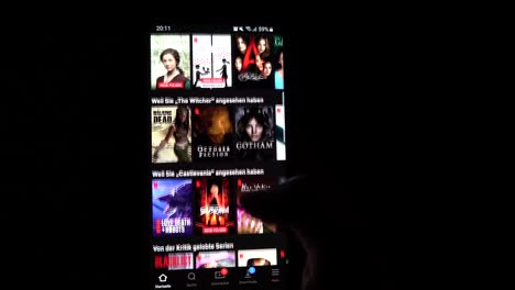Männliche-Hand-Scrollt-Nachts-Netflix-Auf-Seinem-Smartphone