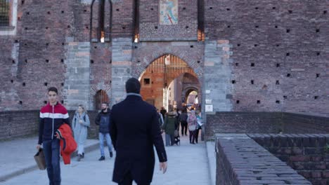 Sforza-castle-main-entrance-gate-with-people-walking-by-during-daytime-in-winter