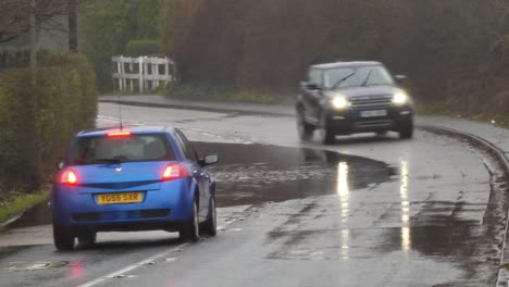 Vehicles-manoeuvre-around-stormy-flash-flooded-road-corner-bend-UK