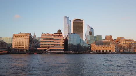 Blick-Auf-Die-Skyline-Des-Städtischen-Modernen-Bürogebäudes,-Vom-Wasser-Aus-Nach-Oben-Schwenkend