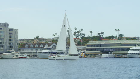 Slow-motion-White-Sailboat-Passing-Through-Harbor-in-Newport