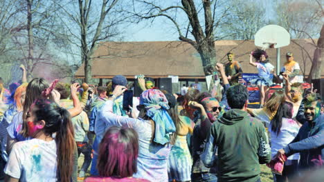 Tiro-Estático-En-Cámara-Lenta-De-La-Multitud-Bailando-Holi-Arrojando-Polvo-De-Colores-Al-Aire