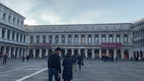 People-Strolling-At-The-Saint-Mark's-Square-In-Venice,-Italy-With-The-Civic-Museo-Correr-Building-In-The-Background---wide-shot