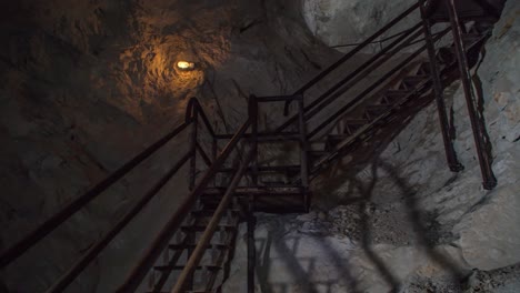 Two-Adults-Walking-Down-Stairs-Inside-Podzemlje-Pece-Tourist-Mine
