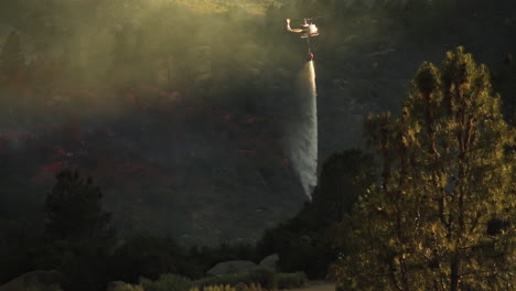California-wildfire:-helicopter-dropping-water-over-forest-fire,-slow-motion