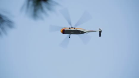 Firefighting-helicopter-flies-low-overhead-searching-for-water-for-nearby-raging-forest-wildland-fire