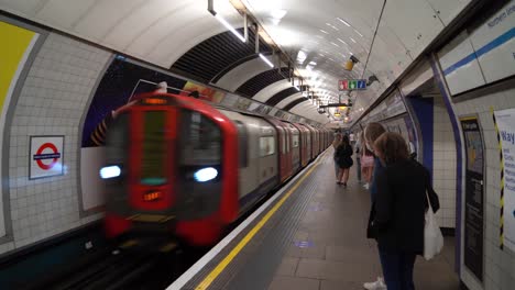 Menschen-Mit-Gesichtsmasken-Gehen-Auf-Sie-Zu,-Während-Ein-Zug-In-Den-Bahnhof-Kings-Cross,-London,-Großbritannien,-Einfährt