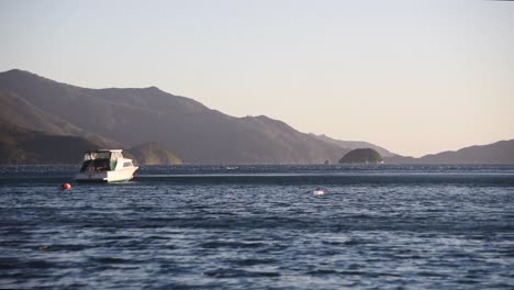 Ein-Weißes-Boot-Wird-Vom-Wind-Im-Tiefblauen-Wasser-Bewegt