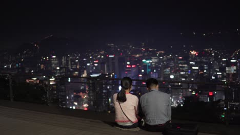 A-couple-wearing-medical-masks-having-a-date-at-Namsan-tower-watching-Night-Seoul
