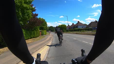 Pov-Siguiendo-Ciclista-Y-Evitando-Baches-En-Moorfield-Road,-Denham,-Uxbridge
