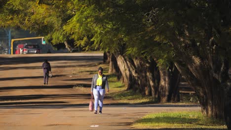 Mujer-Africana-Negra-Con-Mascarilla-Y-Equipo-De-Protección-Personal-Para-Caminar-Por-Una-Calle-Vacía,-Sudáfrica