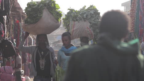 Mujer-Y-Dos-Hombres-Llevando-Productos-A-Través-Del-Mercado-Africano