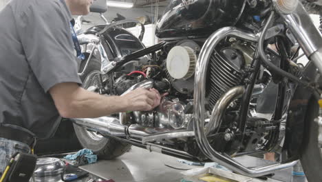 Estudiante-De-Mecánica-Sintonizando-Una-Motocicleta-En-Un-Programa-De-Taller-De-Reparación-De-Una-Escuela-De-Comercio-Tiro-Deslizante