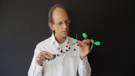 A-biology-science-teacher-educating-via-remote-learning-online-classes-to-school-students-with-a-model-of-a-molecule