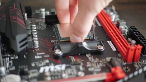 Ein-Computerreparaturtechniker-Installiert-Eine-AMD-Ryzen-2400G-PC-CPU-Auf-Einem-Motherboard-Sockel-Für-Den-Bau-Eines-Gaming-PCs