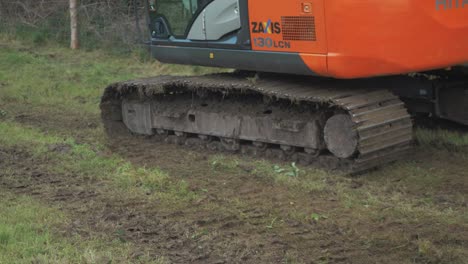 Tracks-of-digger-excavator-driving-in-field-slow-motion