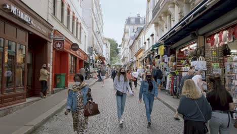 Foto-De-Turistas-Con-Mascarilla-Y-Caminando-Por-La-Calle-De-Montmartre-Durante-La-Pandemia-Del-Coronavirus,-París-Francia