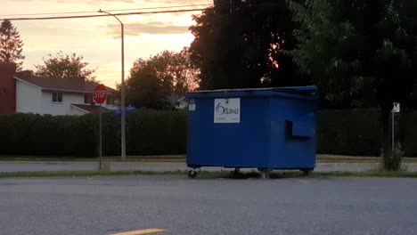 Blauer-Müllcontainer-Der-Stadt-Ottawa-Am-Rande-Des-Parkplatzes-An-Einem-Sommerabend-In-Ottawa,-Ontario,-Kanada